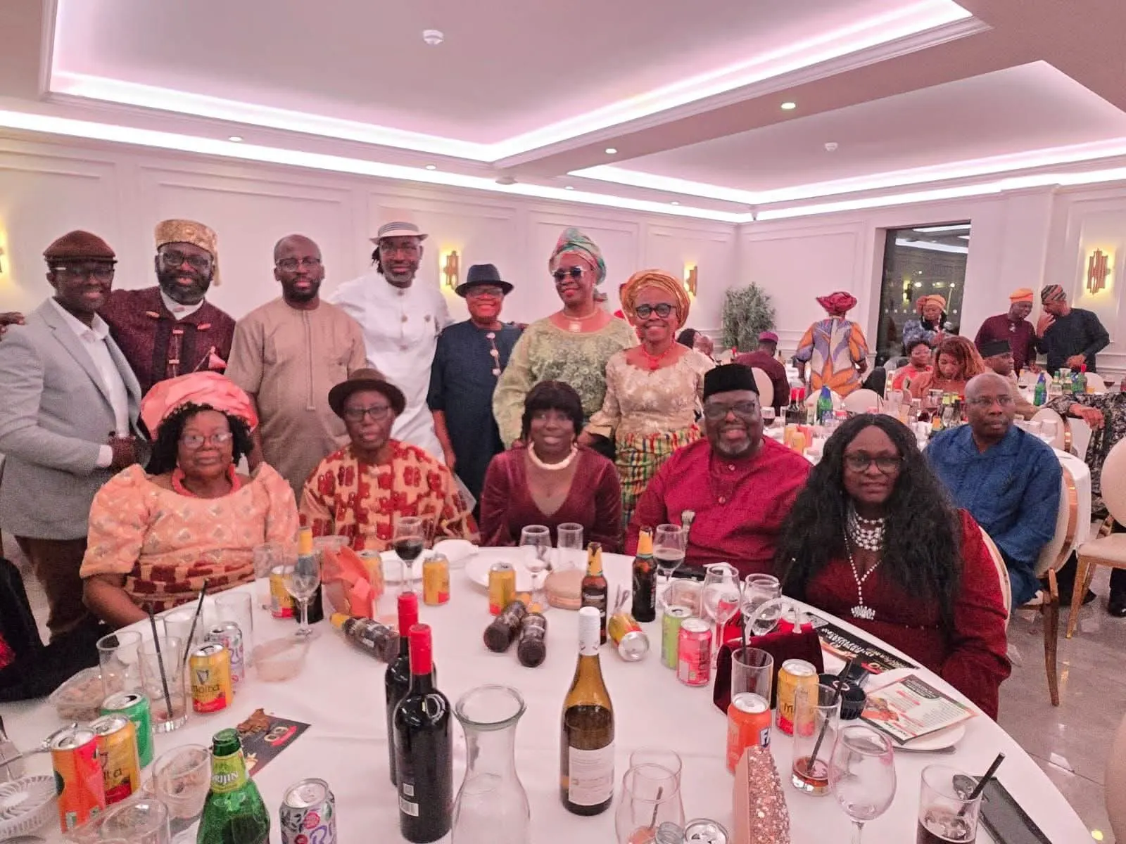 Members seated and standing around a round table in a function hall